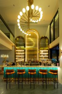 a bar in a restaurant with a chandelier at PĀMA Boutique Hotel and Bistro in Danang