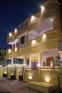 un edificio amarillo y blanco con luces encendidas en La Shashalia Luxury, en Pondicherry