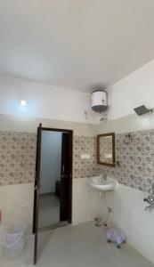 a bathroom with a sink and a toilet and a mirror at Monkey Retreat Resort in Udaipur