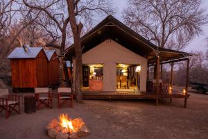 a small cabin with a fire in front of it at Abelana Safari Camp in Phalaborwa