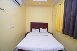 a bedroom with a large bed with white sheets at Hotel Rama Palace in Morādābād