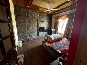 a living room with a bed and a window at New Aashiyana Homestay in Baghwānpur