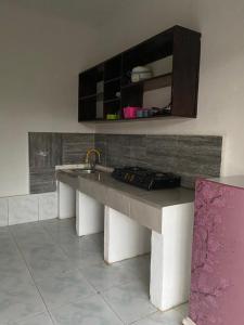 uma cozinha com um banco com um lavatório e um armário em Rocky Homestay Lakey em Huu