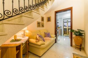 ein Wohnzimmer mit Sofa und Treppe in der Unterkunft Sunny Maltese townhouse Madonnina Kalkara - Happy Rentals in Kalkara