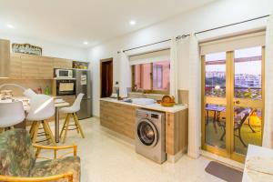 eine Küche und ein Wohnzimmer mit einer Waschmaschine in der Unterkunft Sunny Maltese townhouse Madonnina Kalkara - Happy Rentals in Kalkara