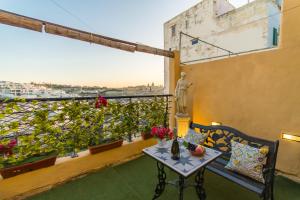 a balcony with a table and a view of a city at Sunny Maltese townhouse Madonnina Kalkara - Happy Rentals in Kalkara