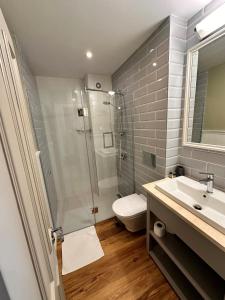 a bathroom with a shower and a toilet and a sink at Predela 2 Aparthotel in Bansko