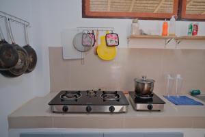 a stove in a kitchen with a pot on it at Copacabana Siargao in General Luna