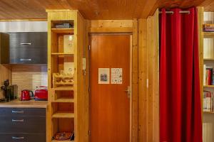 eine Küche mit einem roten Vorhang und einer Tür in der Unterkunft CIEL MONTAGNARD - Apartment with mountain views in Annecy