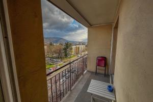 einen Balkon mit einer Bank und Stadtblick in der Unterkunft CIEL MONTAGNARD - Apartment with mountain views in Annecy