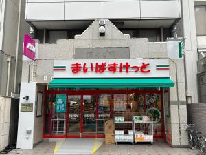 una tienda con un cartel en la parte delantera en HARMONIA東京堀切 10名定員90平米の広いCondominium en Tokio