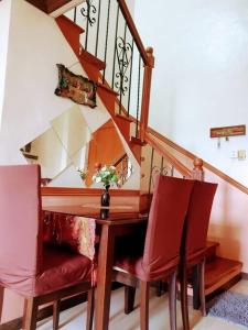 a dining room table with two chairs and a staircase at Greenhills Garden Square in Manila