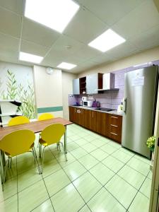 a kitchen with a table and chairs and a refrigerator at eMKa Hostel in Warsaw