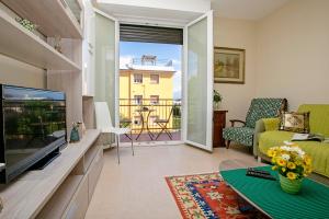 uma sala de estar com uma televisão e um sofá em Villa Mimosa - Appartamento 2 - Happy Rentals em Desenzano del Garda