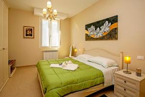 sypialnia z zielonym łóżkiem i oknem w obiekcie Villa Mimosa - Appartamento 2 - Happy Rentals w mieście Desenzano del Garda
