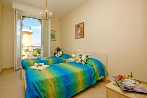 sypialnia z dwoma łóżkami i balkonem w obiekcie Villa Mimosa - Appartamento 2 - Happy Rentals w mieście Desenzano del Garda