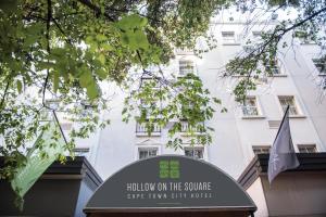 a sign in front of a white building at Hollow on the Square City Hotel in Cape Town