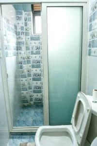 a bathroom with a toilet and a shower with a mirror at City View No 5, Mawanda Road. in Kampala