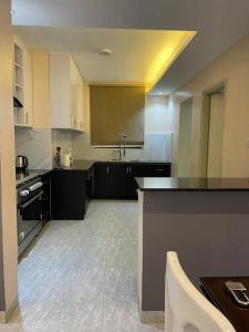 a large kitchen with black cabinets and a sink at City View No 5, Mawanda Road. in Kampala