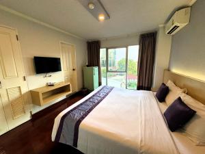 a bedroom with a large bed and a television at The Step Sathon in Bangkok