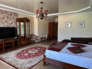 1 dormitorio con 1 cama y TV de pantalla plana en Royal, en Aktobe