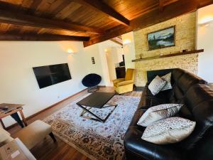 a living room with a leather couch and a television at Pacific Sands Vacation Home in Fort Bragg