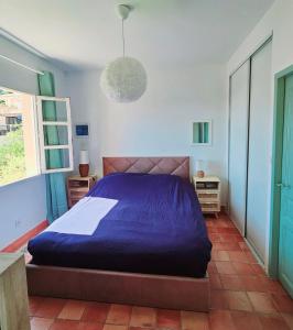 een slaapkamer met een bed met een blauw dekbed bij TRES BEL APPARTEMENT VUE MER - Piscine - Tennis et Golf in Saint-Cyr-sur-Mer