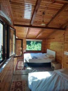 um quarto com 2 camas numa casa de madeira em Gogalay Bungalov Hotel -Restoran em Artvin