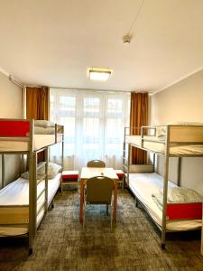 a room with three bunk beds and a table at eMKa Hostel in Warsaw