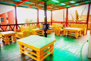 een patio met houten stoelen en tafels en een grill bij Apollo Inn Fortportal in Kigarama