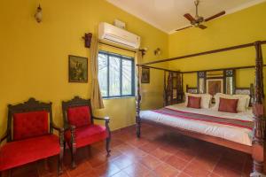 1 Schlafzimmer mit 2 Betten und 2 roten Stühlen in der Unterkunft Vintage Estate - Lakeside allure with vintage decor,A plunge pool & A lawn featuring a charming gazebo in Karjat + 22 Fotos
