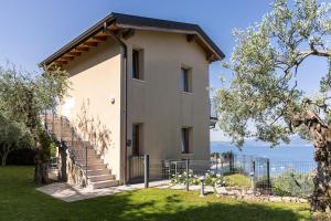 a house with stairs and a view of the ocean at Residence La Corte Danese in Torri del Benaco