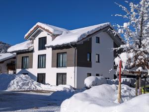 une maison recouverte de neige devant dans l'établissement Bergluftsuite am Breitenberg, à Pfronten