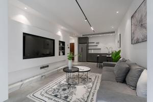 a living room with a couch and a tv on a wall at Deluxe One-bedroom Apartment Black and White Gray Modern Style Designer Brand Central Air Conditioning in Shanghai