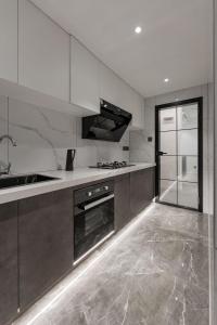 a kitchen with stainless steel appliances and white cabinets at Deluxe One-bedroom Apartment Black and White Gray Modern Style Designer Brand Central Air Conditioning in Shanghai
