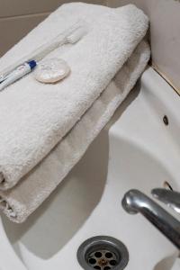 uma toalha branca sentada em cima de um lavatório em Miraa Guest House & Resto em Denpasar