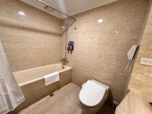 ein Badezimmer mit einem WC und einer Badewanne in der Unterkunft T Hotel in Taichung