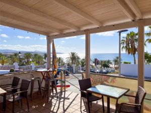 a balcony with tables and chairs and a view of the ocean at Casa Weimar in Costa Calma