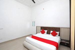 OYO Diamond Resort في الوار: غرفة نوم بسرير كبير ومخدات حمراء