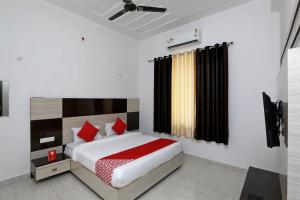 una camera da letto con un letto con cuscini rossi di OYO Diamond Resort a Alwar