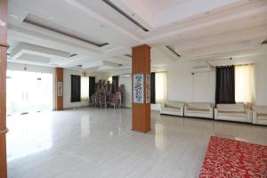 Habitación grande con sillas y alfombra roja. en OYO Diamond Resort en Alwar