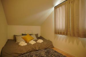 a bedroom with a bed with two towels on it at 【5名様まで宿泊費用変動なし！】落ち着いた雰囲気を味わえる白を基調としたモダンスタイルな貸切一軒家！ in Meta