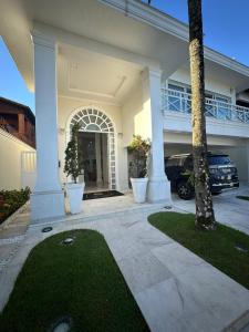 a house with a palm tree and a driveway at Enseada Premium Suítes in Guarujá