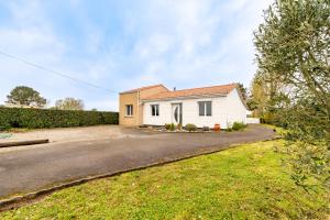 a small white house with a driveway at L'ancrage - 5 minutes de la mer in La Plaine-sur-Mer