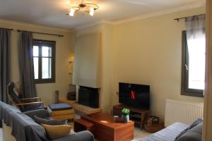 a living room with two couches and a tv at Elatos Sea House in Kato Gatzea