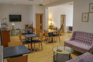 - un salon avec un canapé, des tables et des chaises dans l'établissement Oscar Lodge, à Northampton