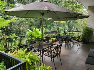 a patio with tables and chairs and an umbrella at ANNIE KUCA in Jakarta