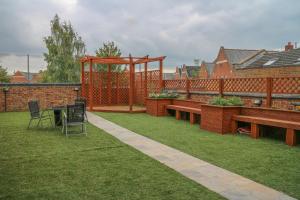 a garden with benches and a gazebo at Oscar Lodge in Northampton