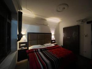 een slaapkamer met een groot bed en een rode deken bij Hotel Premier Mall Road Manali in Manāli