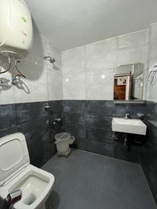 a bathroom with a toilet and a sink at Hotel Premier Mall Road Manali in Manāli